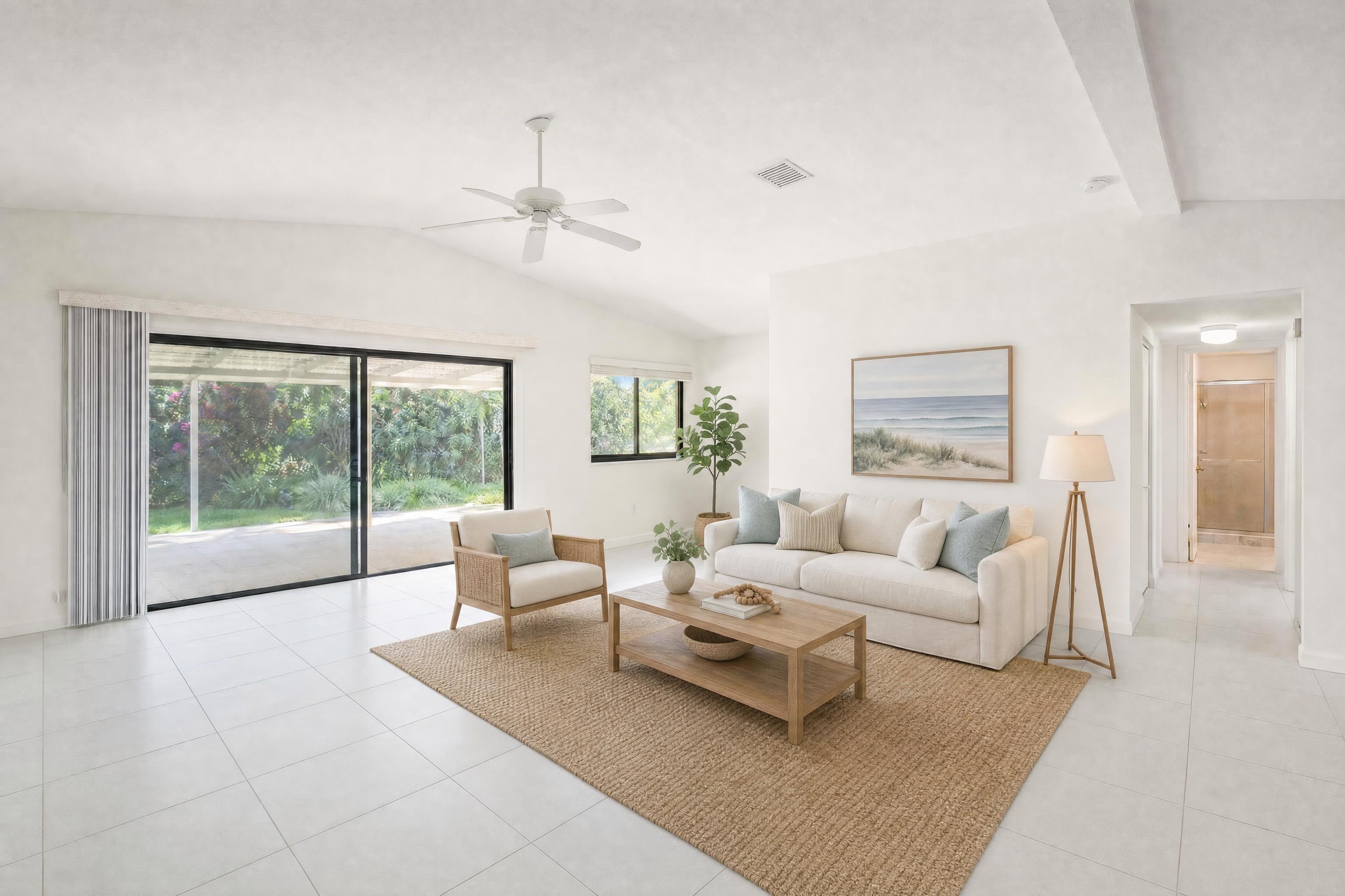 Living room in a bright single-story home in a warm climate, virtually staged in a coastal style